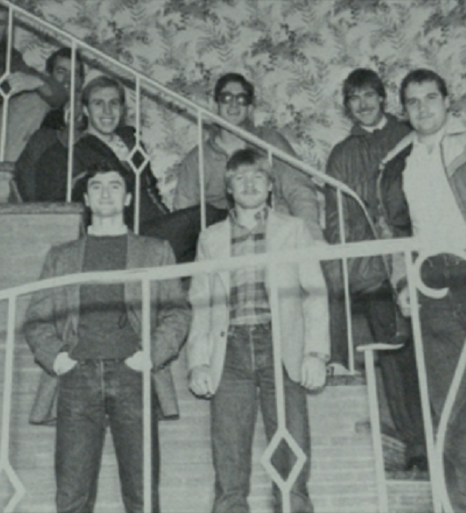 Members of Pi Kappa Alpha, about 8, standing on the stairs of their soon to be house