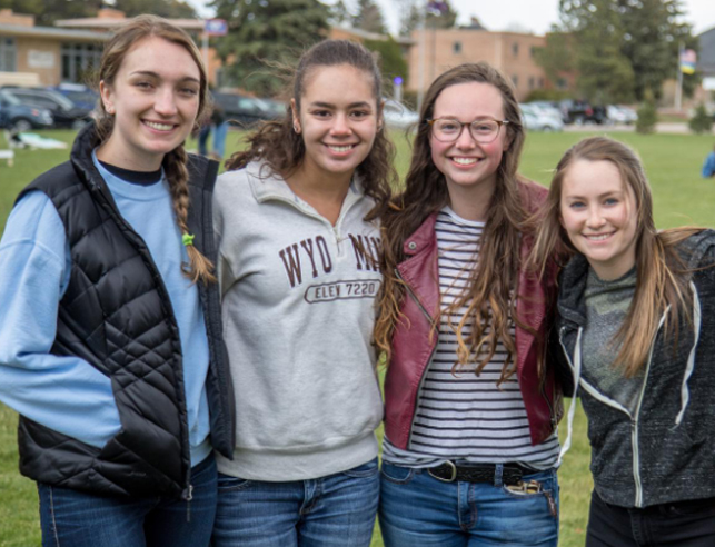Four female students standing and smiling