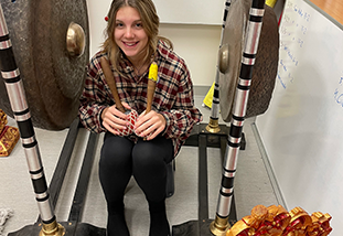 student playing gongs in gamelan