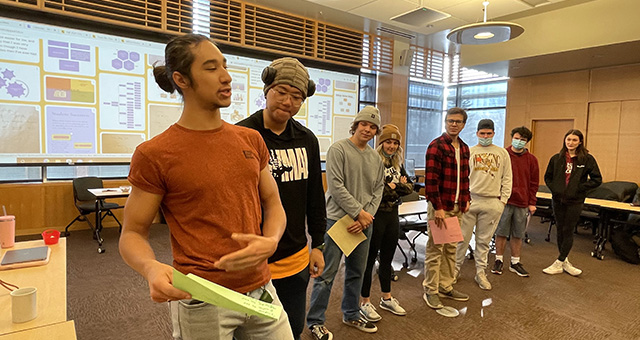 group work of two groups of students working in front of white board