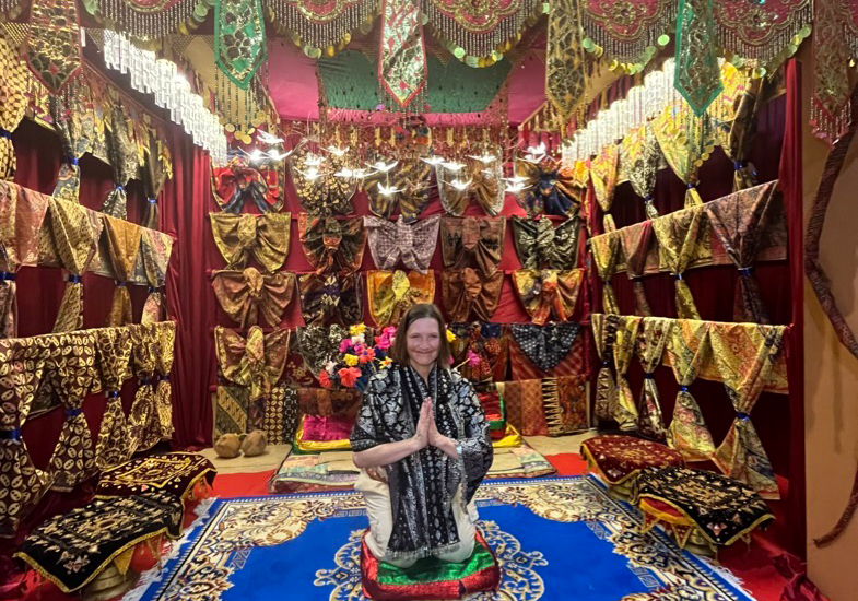 Mollie kneeling in a traditional Jambi house