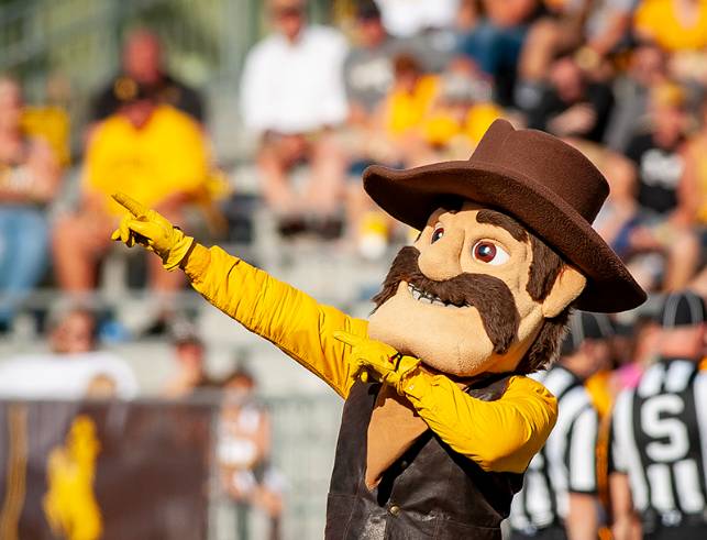 University of Wyoming mascot Pistol Pete points to fans at a football game