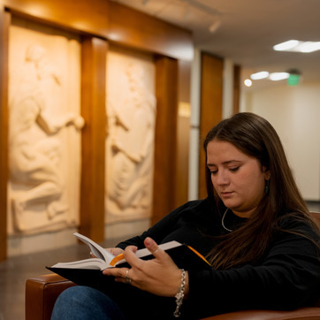 a student is reading at the UW College of Law building