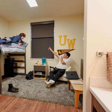 two students talk in a dorm room