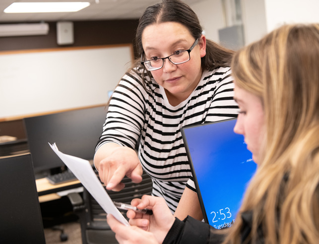 A teacher works with a student on a project