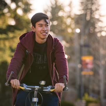 man riding bike on campus