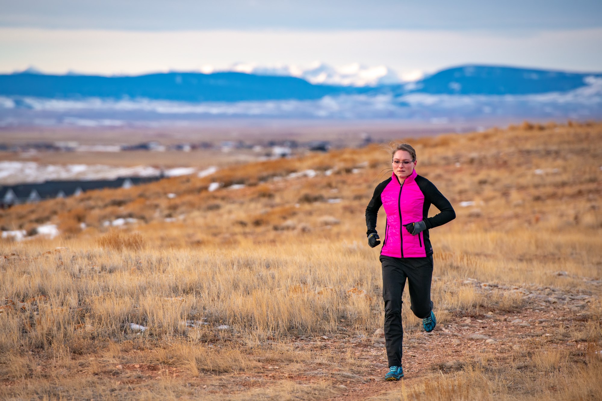A student focuses on their laptop while studying in a classroom.