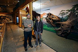 Two people stand in front of a new exhibit about the Cretaceous period in the geology museum.