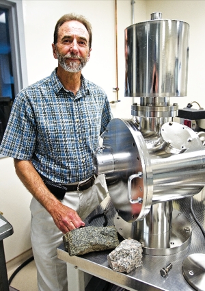 Kevin Chamberlain standing by lab instruments.