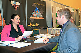 Woman behind desk interviewing a man.