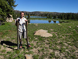 man with sediment cores standing in meadow