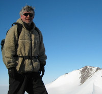 Man in jacket with snow covered mountain in background