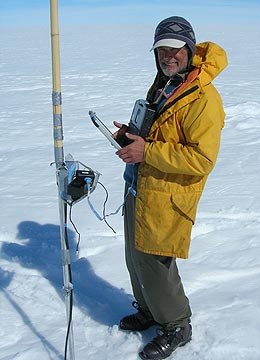 Man stands next to a temperature sensor instrument in Greenland.