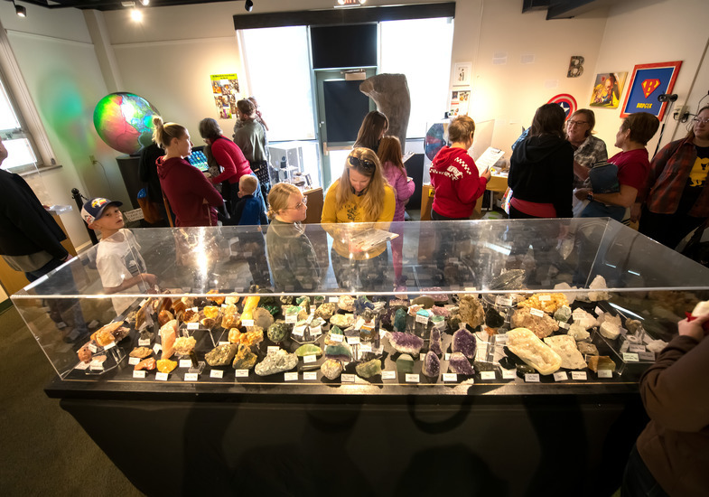 Elementary-aged students with clipboards examine rock and fossil displays at the UW Geological Museum.