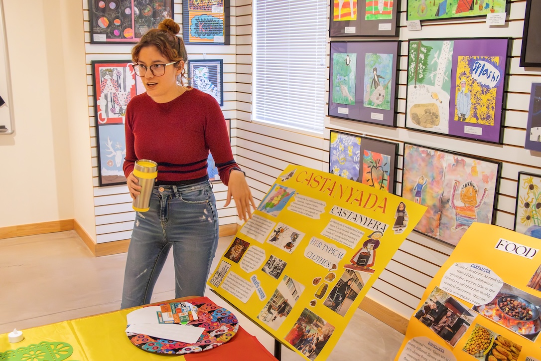 A Fulbright student shares a poster on Castanyada at an event