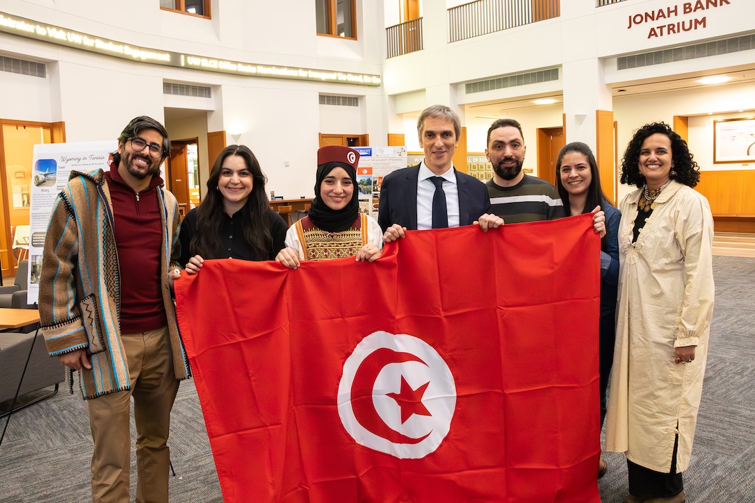 Seven scholars from Tunisia with the Tunisia flag in the UW Business College