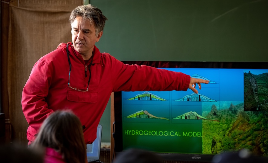 faculty member pointing at screen while giving presentation