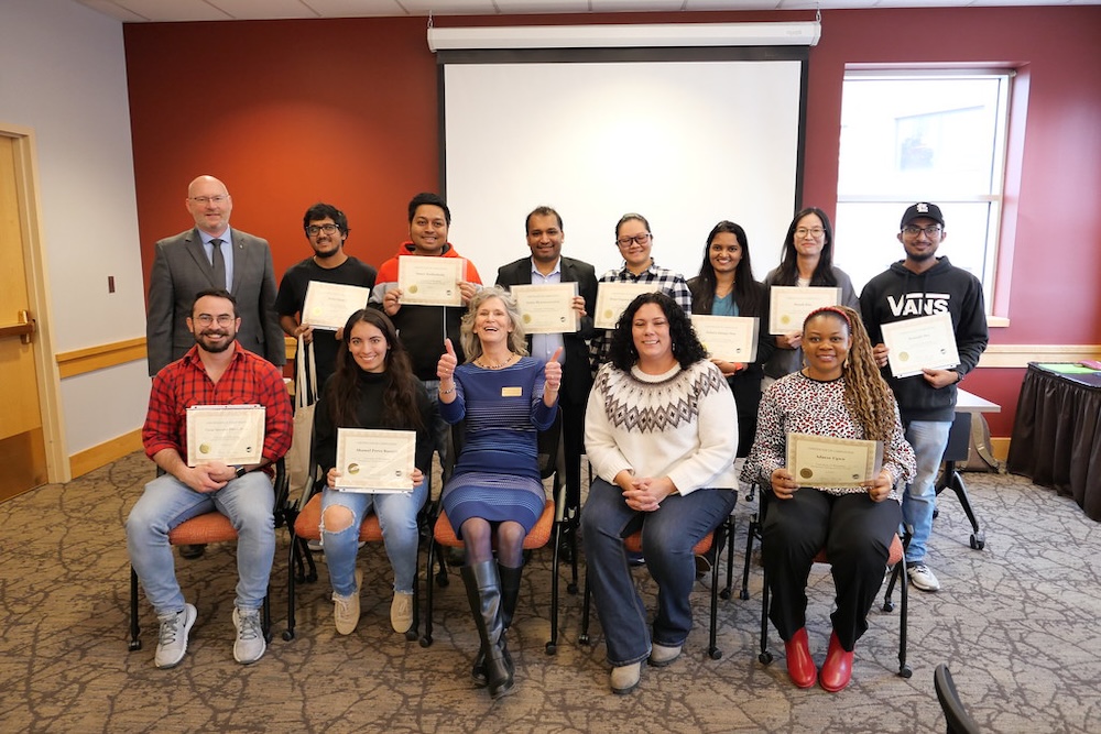 students sitting and smiling with awards