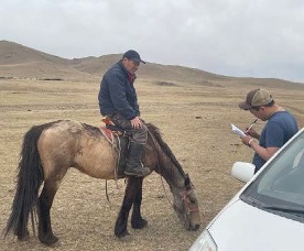 man on a horse next to a man with a clipboard