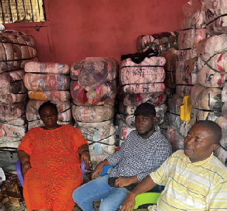 Student with two others in a room in Ghana