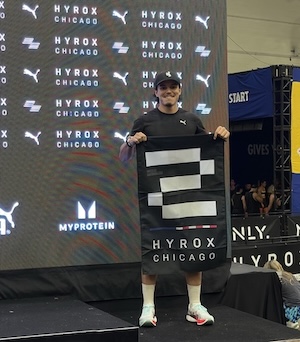 Hamza standing on the podium with a flag