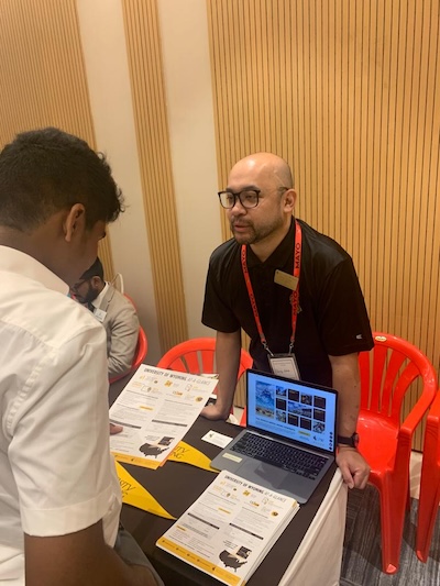 Daing talking to a student at a fair