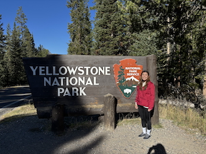 Haruka Takaku in front of Yellowstone National Park sign