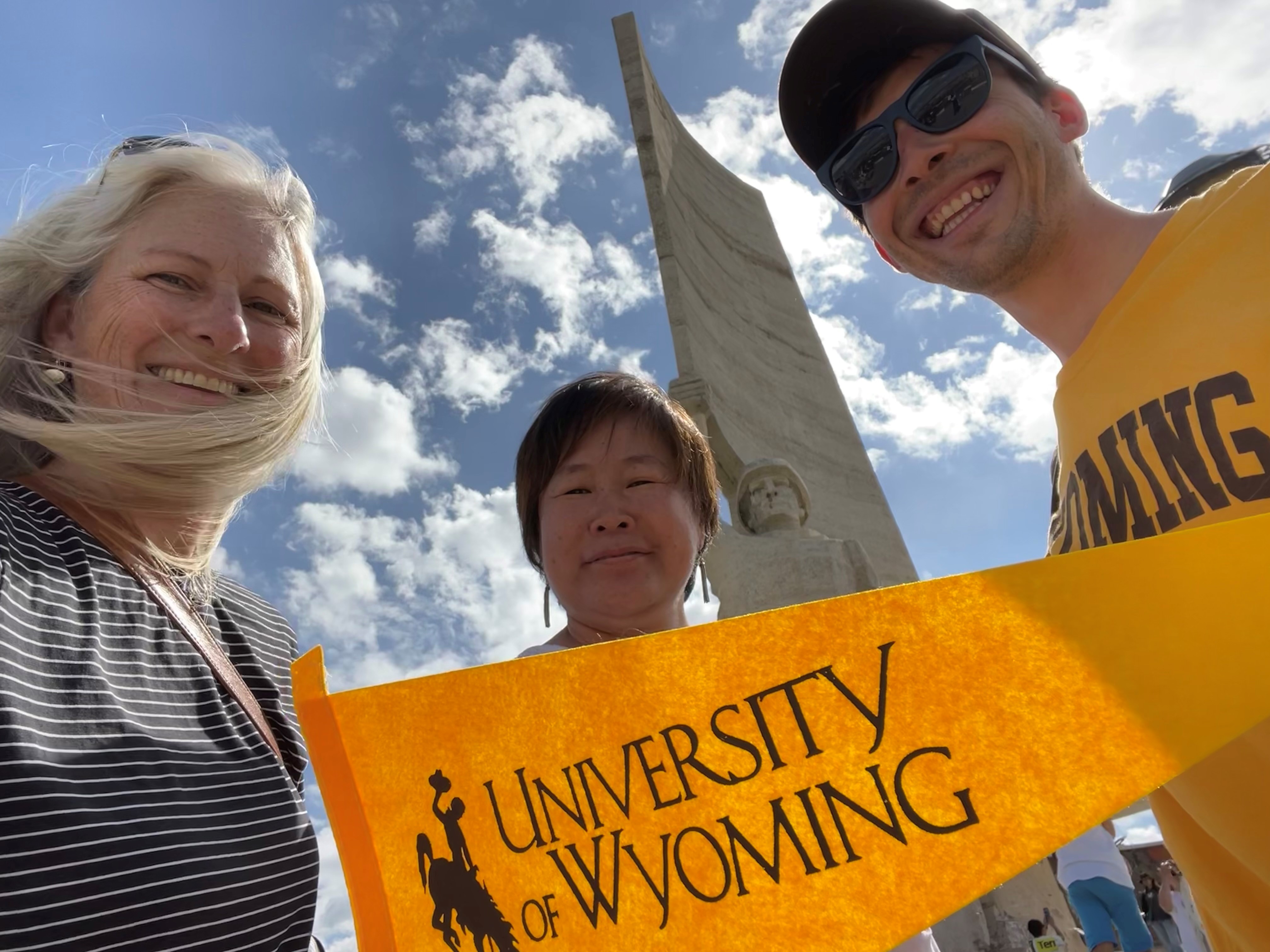 Isa, Nick, and Bujidmaa with UWyo flag