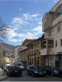 cars and apartments line a small street