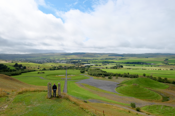 Man standing between two stones in Scotland