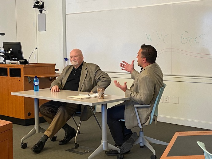 Two presenters talking a table in a lecture room
