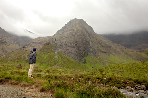 Man looking at mountain by Fairy Pools in the Isle of Sky
