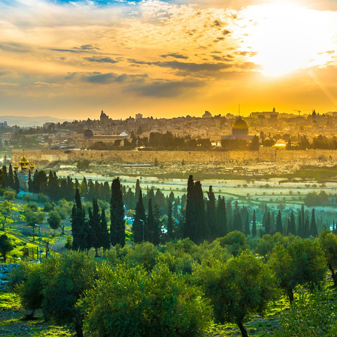 The sun sets behind a landscape photo of the city of Jerusalem.