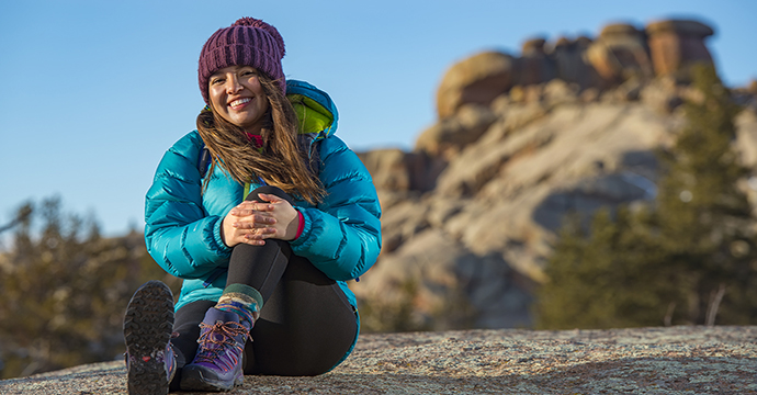 Picture of woman sitting on rock with winter coat in vedauwoo