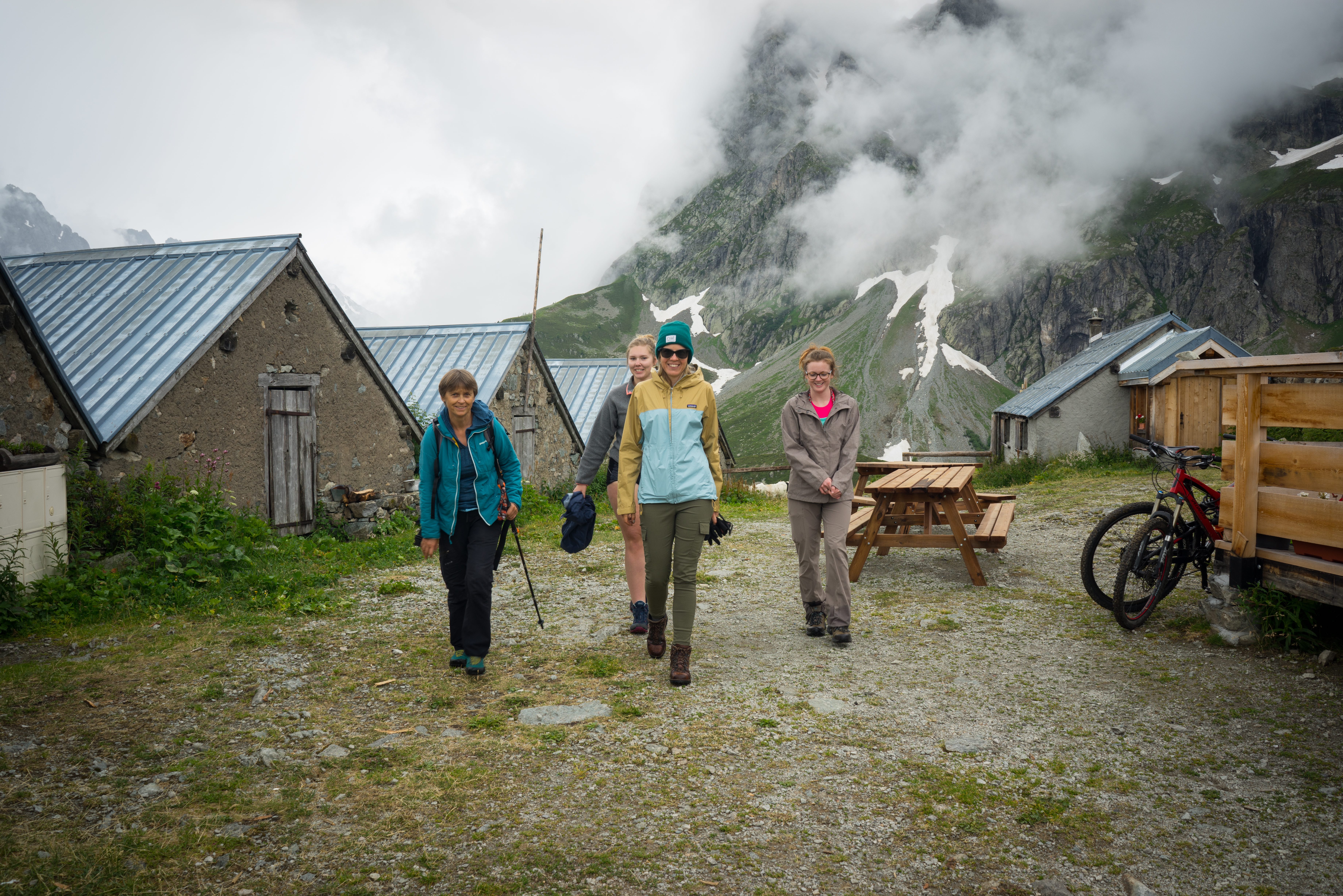 group of four people walking in the mountains