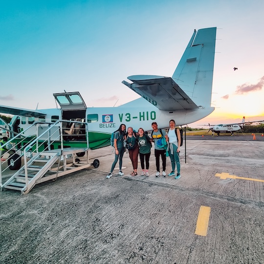 students standing in front of airplane