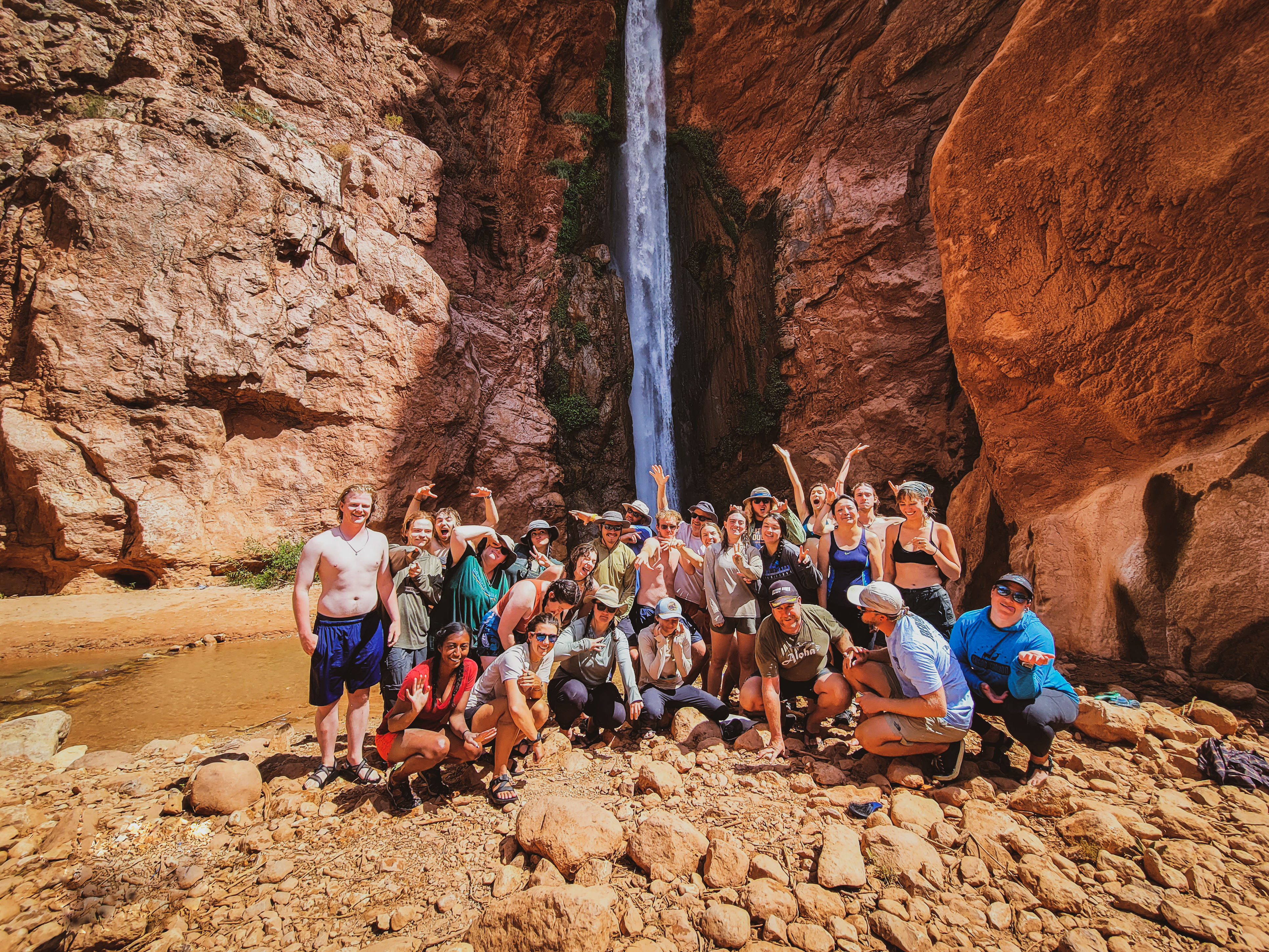 group of people in front of waterfall