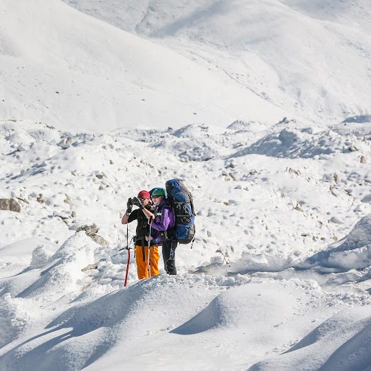 two people with backpacks in a snowy, winter landscape