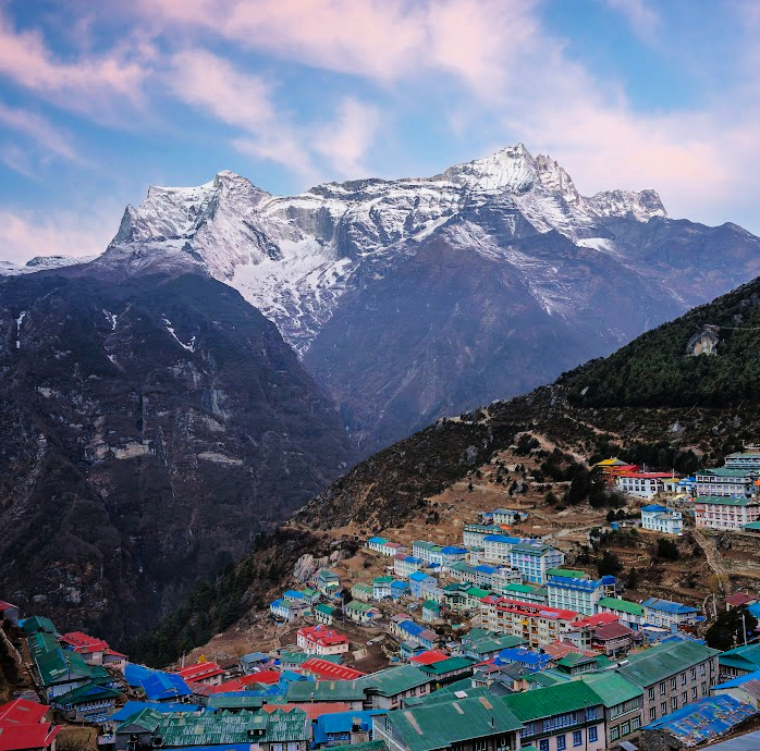 colorful roofs of buildings with looming mountains in background