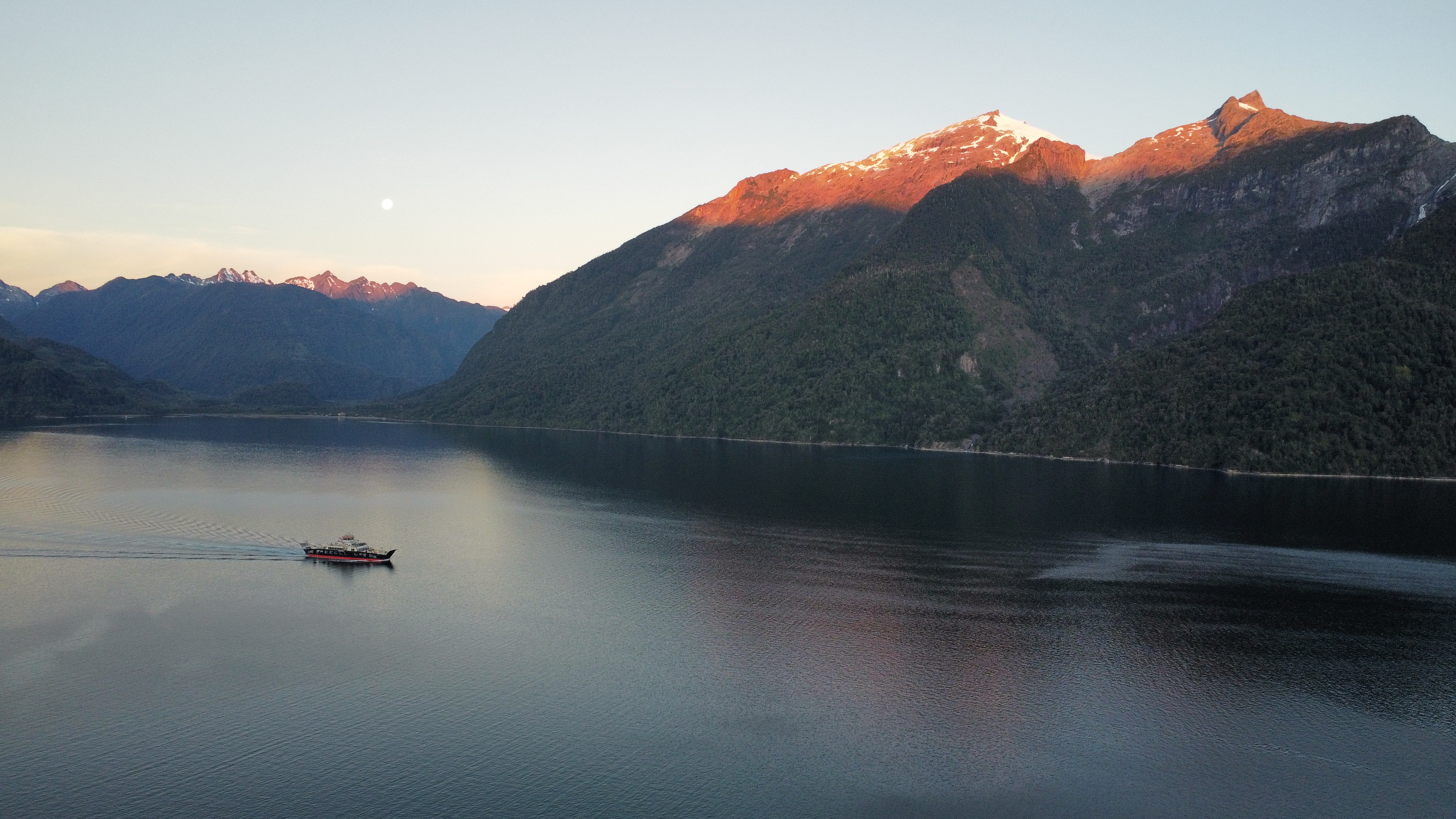 a boat in front of mountains