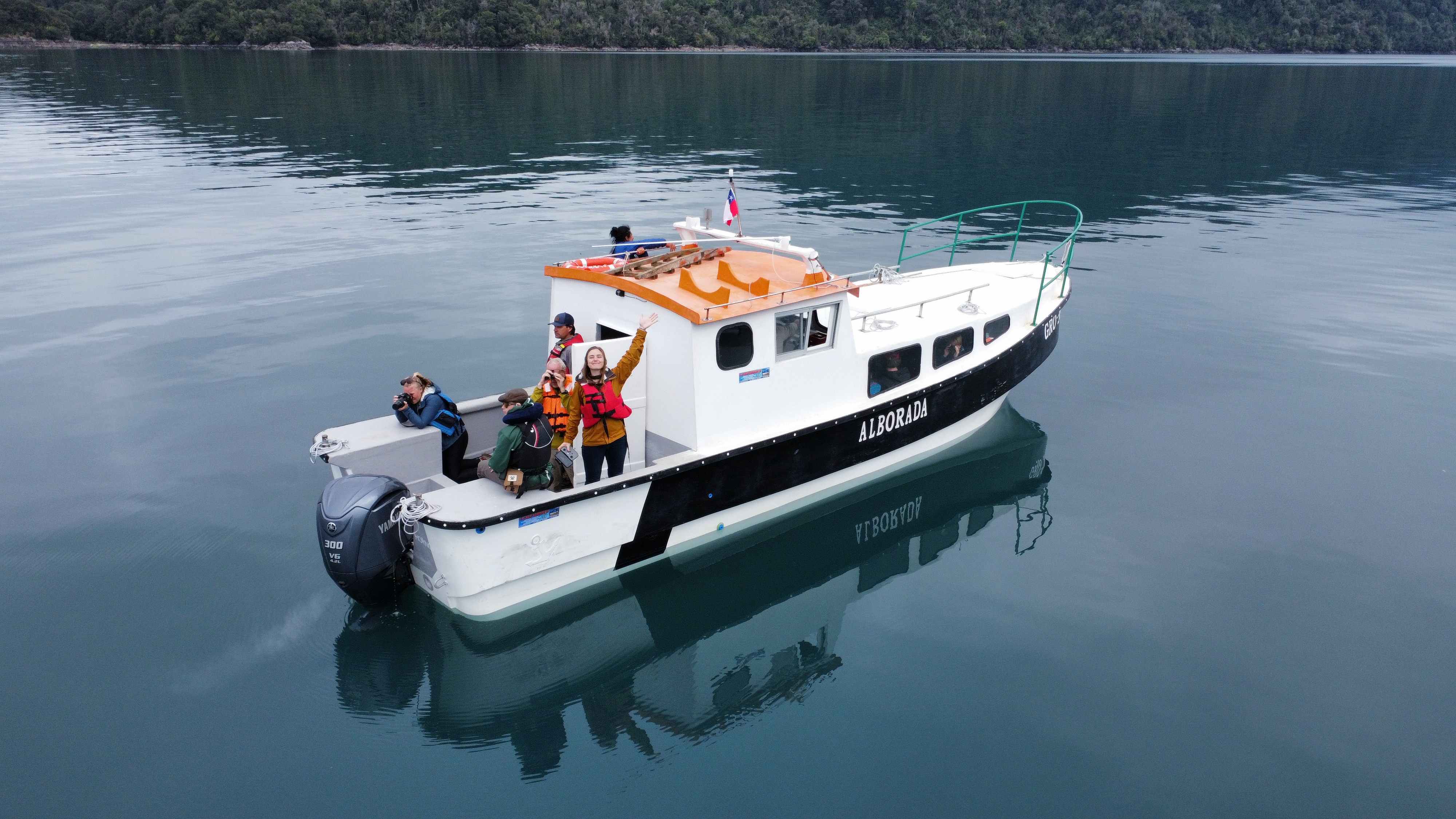 students on a boat waving 