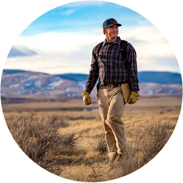 student walking in field with notebook