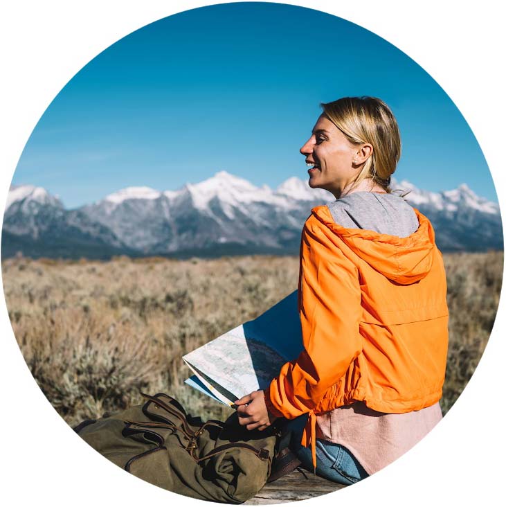 Female student with map looking at mountains