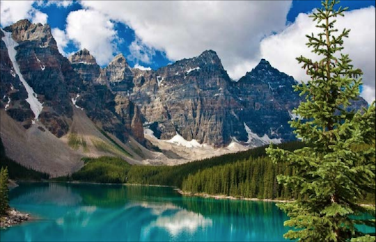 Photo of mountains behind a lake and trees