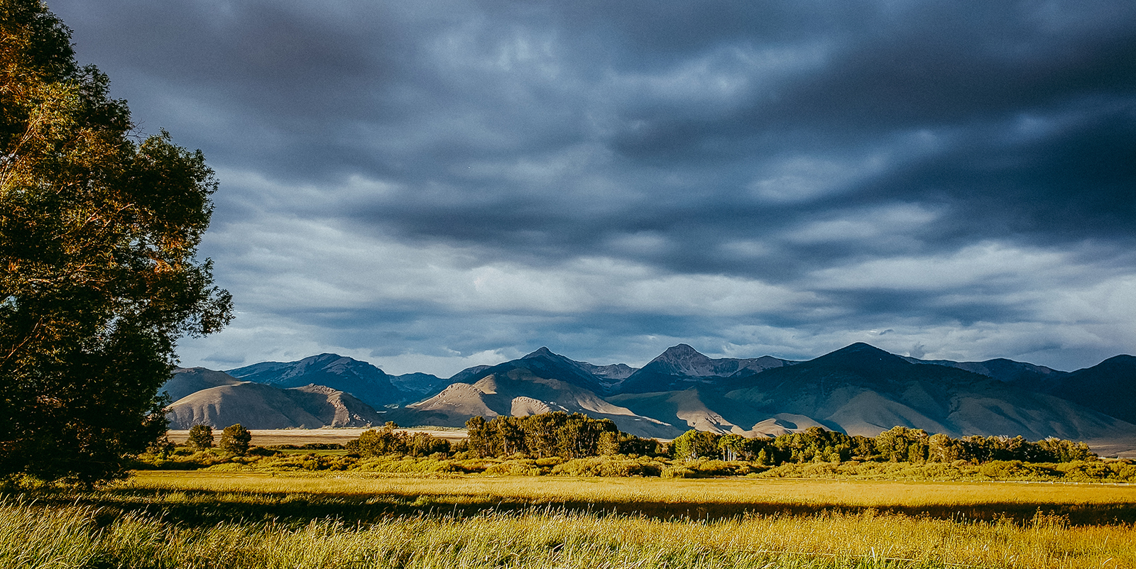 A stormy sky over mountains and foothills