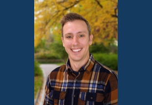 A headshot of Alex Hancock