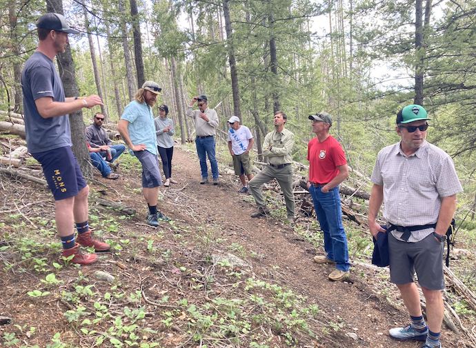 A group of people discussing on a trail