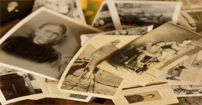 several black and white photographs scattered on a table