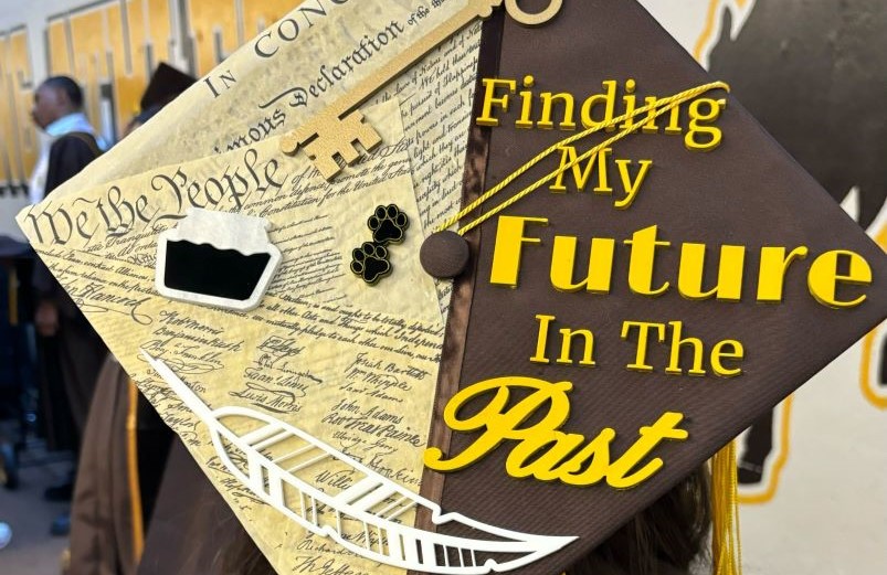Photo of graduation cap that says "Finding My Future in the Past"