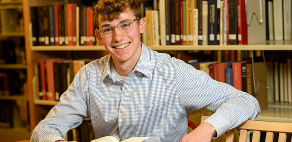 student in the library reading at a table